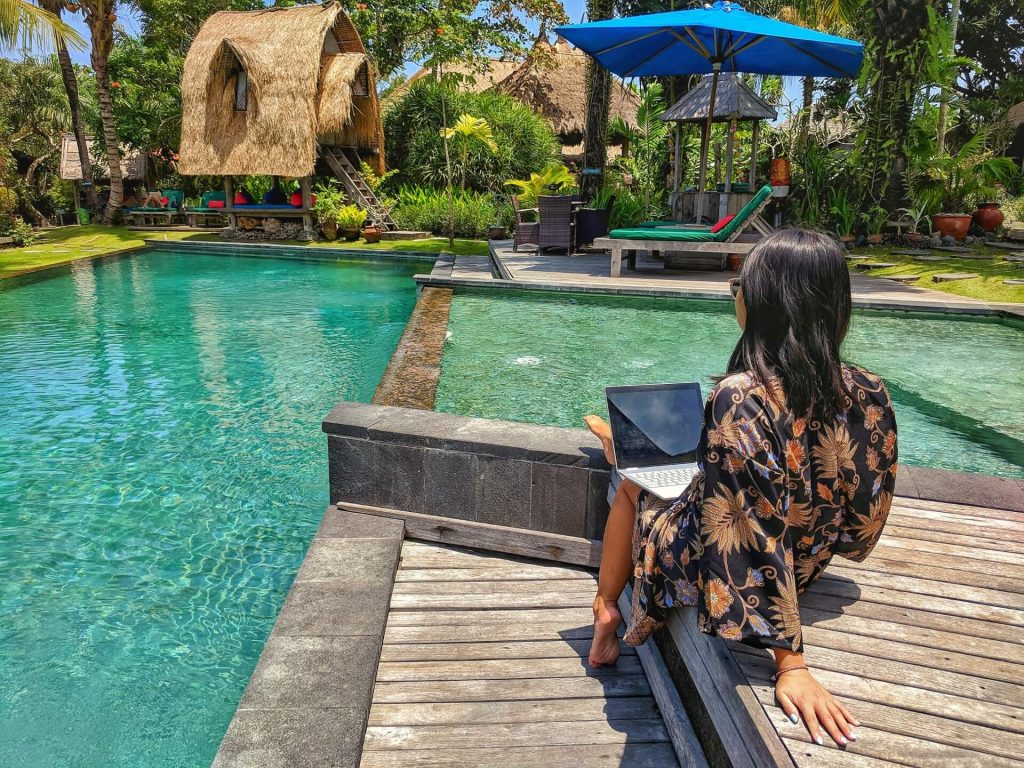 Eat, Pray, Slay in Bali starting a travel blog working on laptop by the pool
